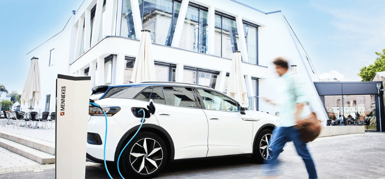 Elektrische wagen laadt aan een MENNEKES laadstation bij een bedrijfsgebouw volgens de EPBD IV-richtlijn – Stagobel