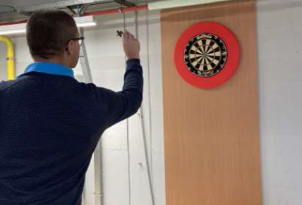 Introductie van het dartsbord Een Stagobel medewerker speelt darts